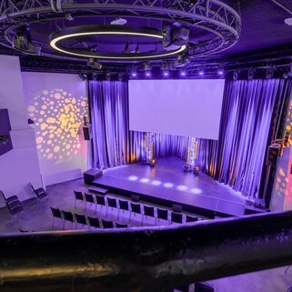 Eventlocation novum Lerchenfelder Straße - Mainhall mit Theaterbestuhlung und Showlicht aus Sicht der Galierie